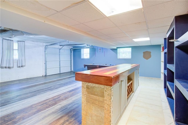 interior space featuring open shelves, billiards, a drop ceiling, and light wood-style flooring