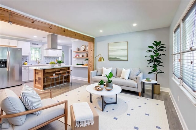 living room with baseboards, recessed lighting, and light wood-type flooring