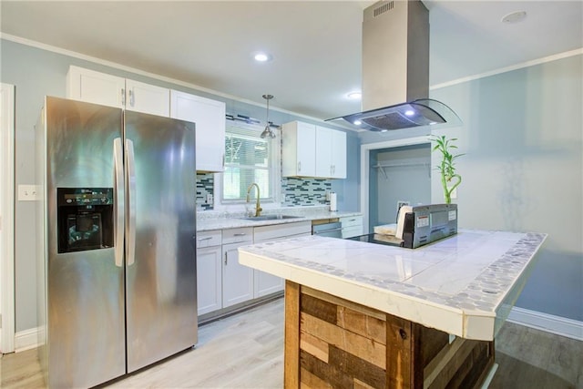 kitchen with a sink, island range hood, crown molding, white cabinetry, and appliances with stainless steel finishes