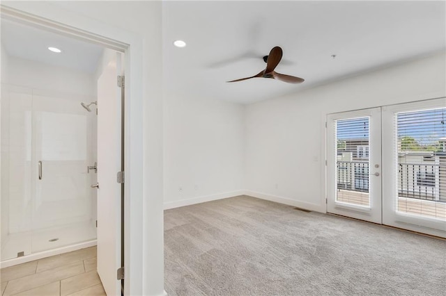 carpeted spare room featuring french doors and ceiling fan