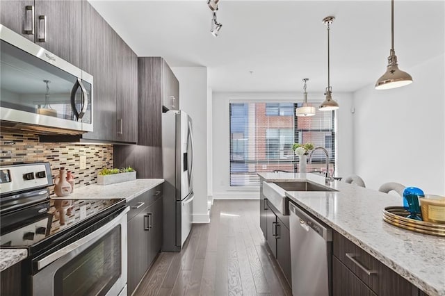 kitchen featuring dark brown cabinets, sink, light stone counters, and stainless steel appliances