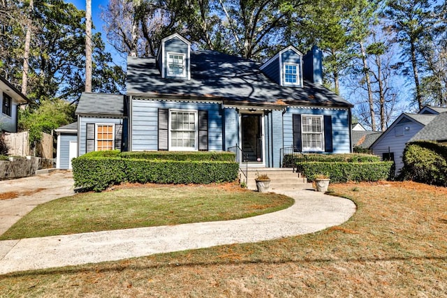 cape cod home featuring a front lawn and a garage