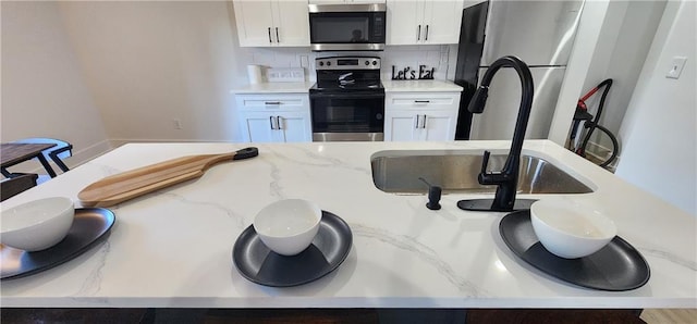 kitchen with tasteful backsplash, appliances with stainless steel finishes, a breakfast bar area, and white cabinets