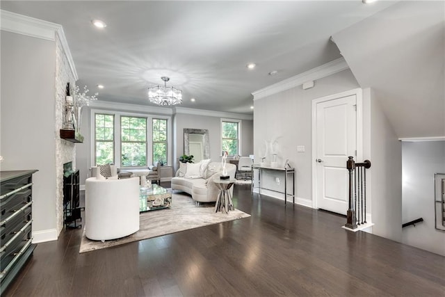 living room with a notable chandelier, crown molding, a fireplace, and dark wood-type flooring