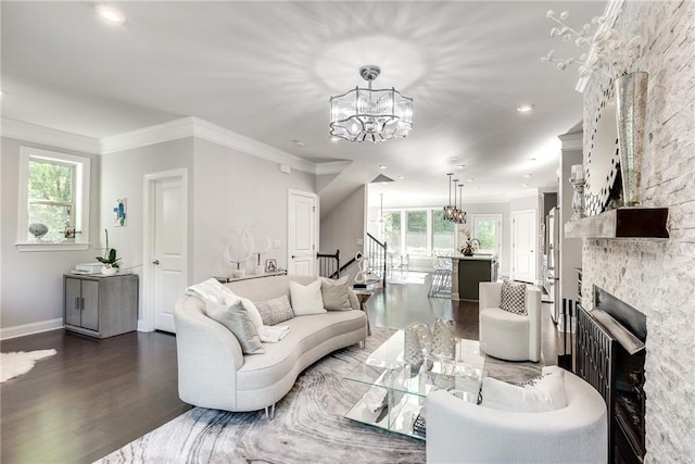 living room with ornamental molding, plenty of natural light, dark hardwood / wood-style floors, and a notable chandelier