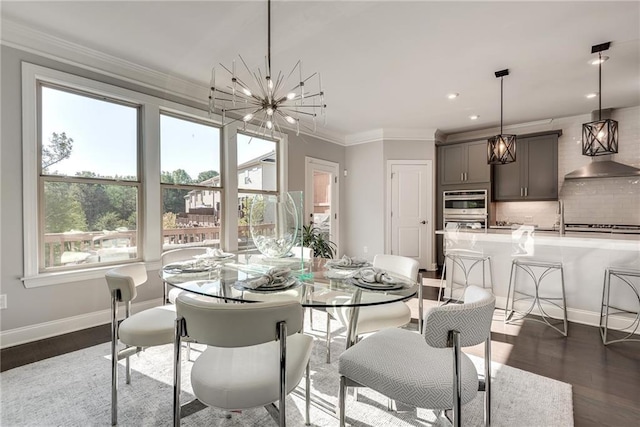 dining room featuring an inviting chandelier, dark hardwood / wood-style flooring, sink, and crown molding