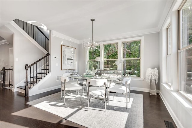 dining room featuring crown molding, dark hardwood / wood-style floors, and a chandelier