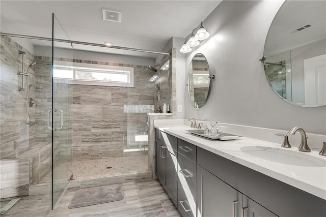 bathroom featuring vanity and a shower with door