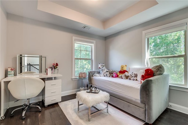 bedroom featuring dark wood-type flooring and a raised ceiling