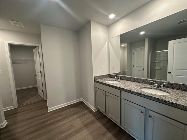 15 Fontana Ct, Covington, GA 30016 - full bath with wood finished floors, double vanity, a shower with door, a spacious closet, and recessed lighting