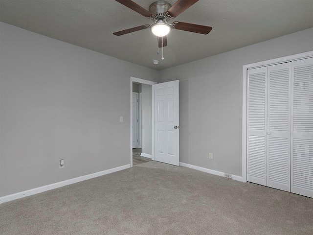 unfurnished bedroom featuring ceiling fan, a closet, and light carpet