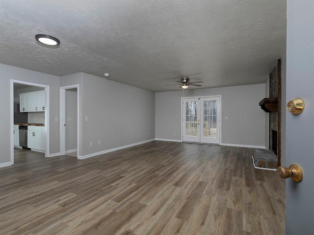 unfurnished living room with hardwood / wood-style flooring, ceiling fan, french doors, and a textured ceiling