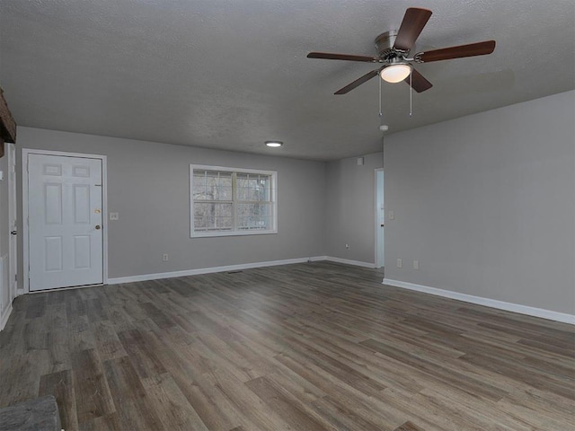 unfurnished living room featuring ceiling fan, dark hardwood / wood-style floors, and a textured ceiling