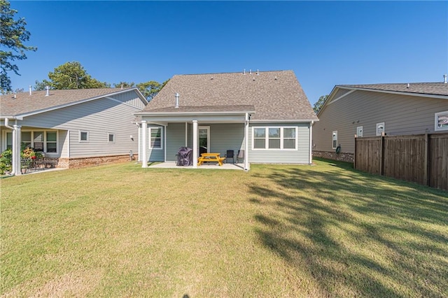 rear view of house featuring a lawn and a patio area