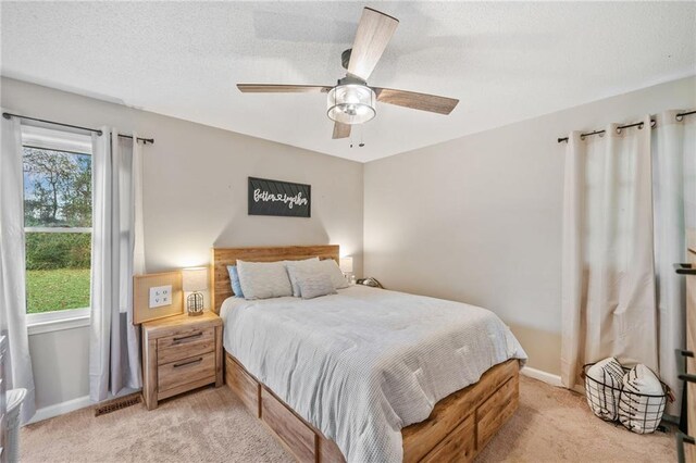 carpeted bedroom with connected bathroom and ceiling fan