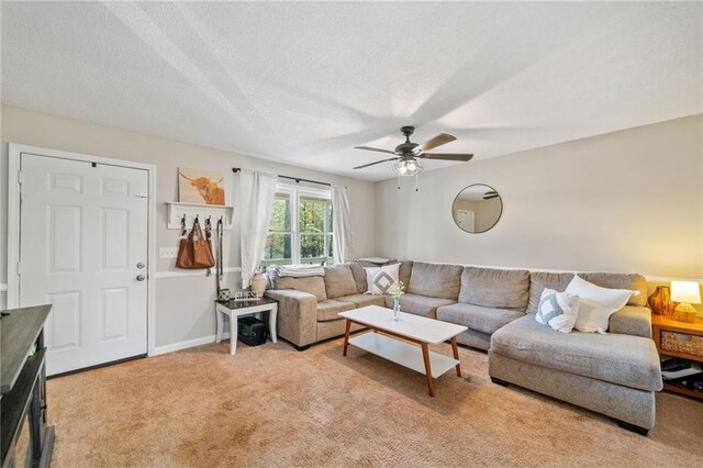 living room with a textured ceiling, ceiling fan, and light carpet