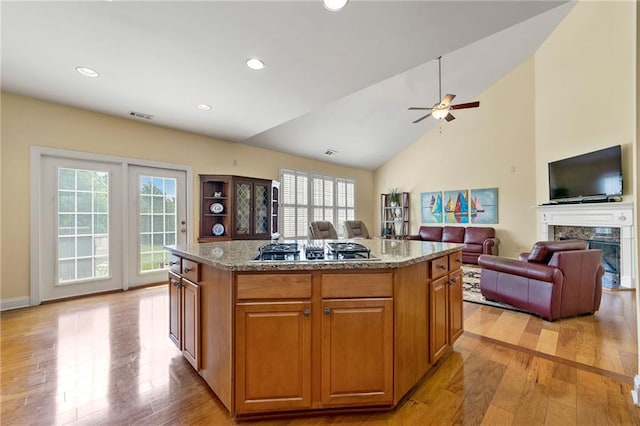 kitchen with gas stovetop, plenty of natural light, light wood finished floors, lofted ceiling, and recessed lighting