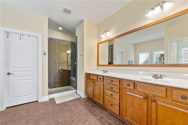 full bath featuring a stall shower, double vanity, baseboards, and tile patterned flooring