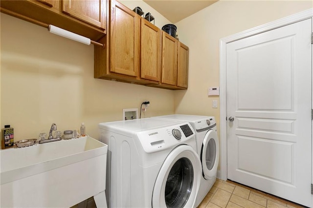 laundry area with cabinet space, separate washer and dryer, and light tile patterned floors