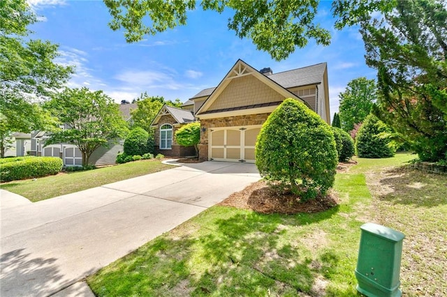 craftsman-style home featuring driveway, stone siding, a front lawn, and an attached garage