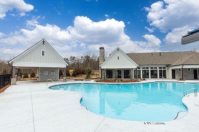 community pool featuring fence and a patio area