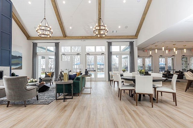 dining room featuring a chandelier, high vaulted ceiling, light wood finished floors, beam ceiling, and french doors
