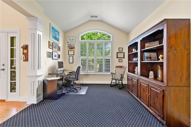 home office with decorative columns, vaulted ceiling, dark carpet, and baseboards