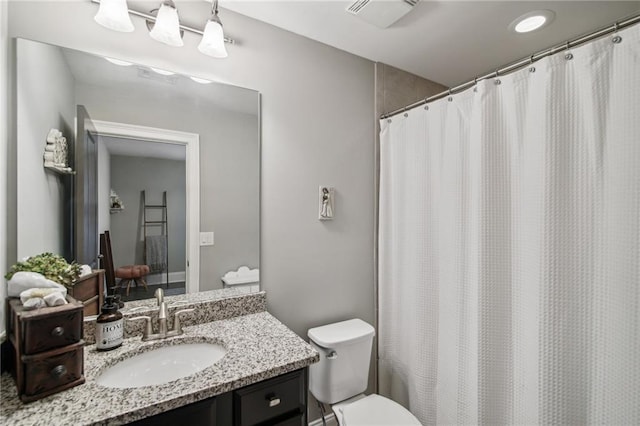 bathroom with vanity, a shower with shower curtain, and toilet