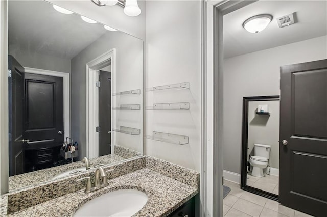 bathroom with vanity, toilet, and tile patterned flooring