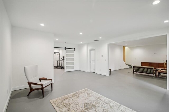 sitting room featuring concrete floors and a barn door