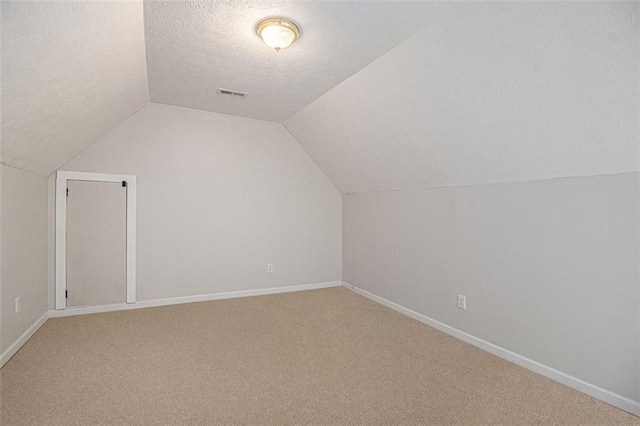 232 Christian Cir, Carrollton, GA 30116 - additional living space with lofted ceiling, a textured ceiling, light colored carpet, and baseboards