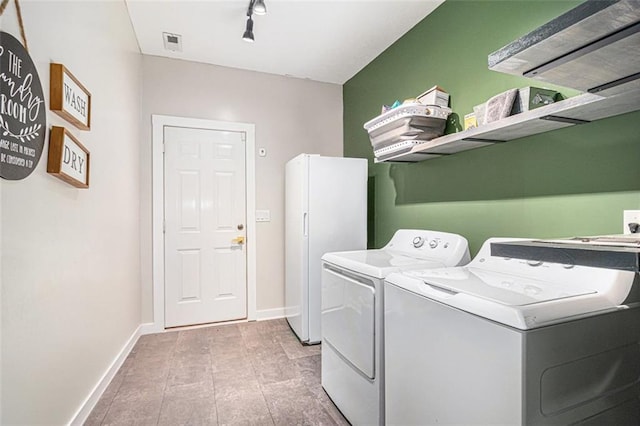 232 Christian Cir, Carrollton, GA 30116 - laundry area featuring washer and clothes dryer, baseboards, and rail lighting