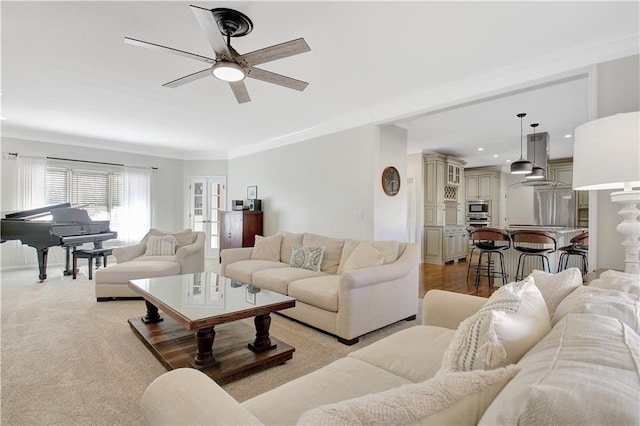 living room with ceiling fan and ornamental molding