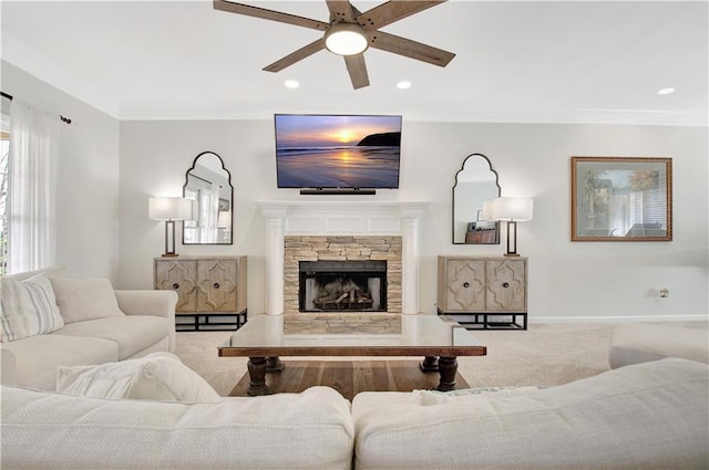 living room featuring carpet, ceiling fan, a fireplace, and ornamental molding