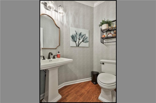 bathroom featuring hardwood / wood-style flooring, toilet, and ornamental molding