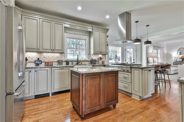 kitchen featuring island exhaust hood, hanging light fixtures, appliances with stainless steel finishes, and a kitchen island