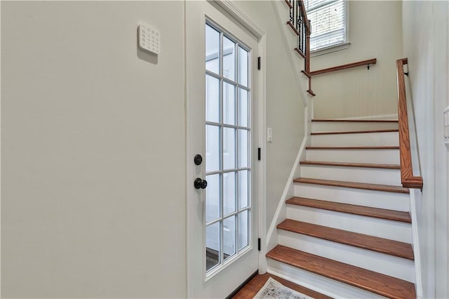 stairs featuring plenty of natural light and wood-type flooring