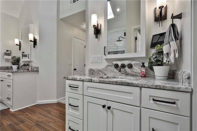 kitchen with hanging light fixtures, sink, light stone counters, and white cabinetry