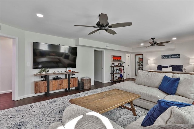 living room featuring ceiling fan and dark wood-type flooring