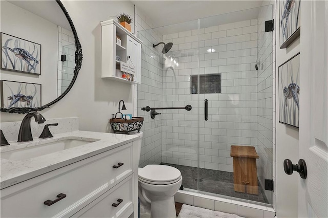 bathroom with toilet, vanity, and an enclosed shower