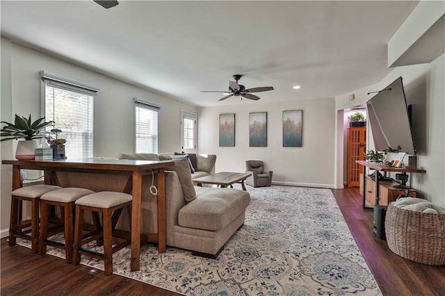 living room featuring ceiling fan and dark wood-type flooring