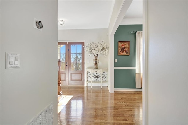 hallway with light hardwood / wood-style flooring and french doors