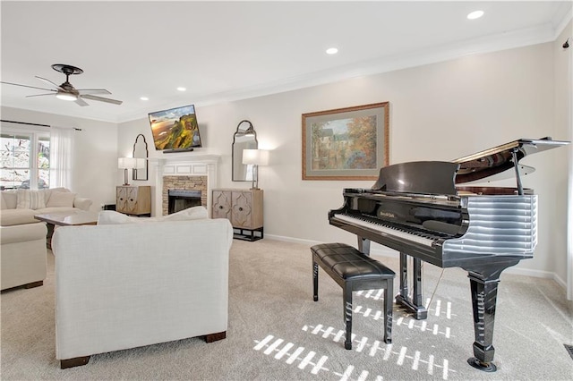 living room with light carpet, ceiling fan, ornamental molding, and a stone fireplace