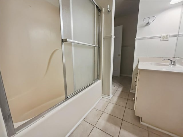 bathroom with combined bath / shower with glass door, vanity, and tile patterned flooring