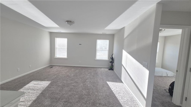 spare room featuring carpet floors and baseboards