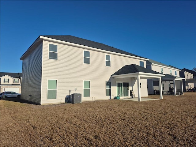 rear view of house with a patio area, a yard, and central AC unit