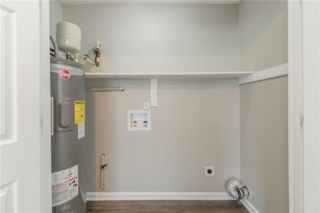 clothes washing area with dark wood-type flooring, hookup for an electric dryer, hookup for a washing machine, and electric water heater