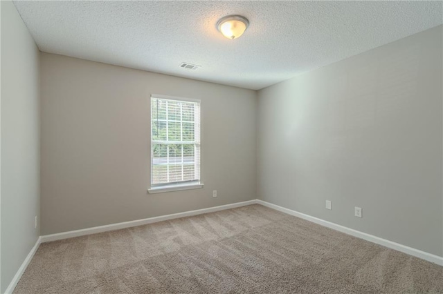 carpeted spare room featuring a textured ceiling