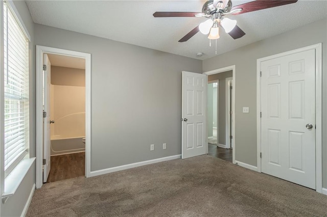 unfurnished bedroom featuring ensuite bathroom, ceiling fan, and carpet