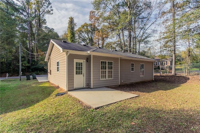 back of house with a lawn and a patio